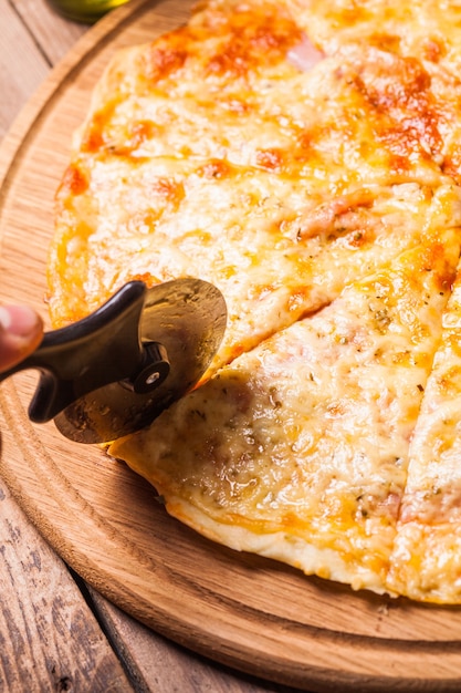 Pizza Margarita on the wooden board and pizza cutter