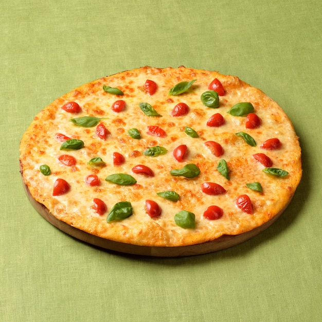 Pizza Margharita op groene linnen achtergrond. Populair fastfood over de hele wereld.