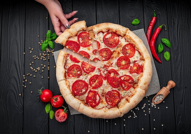 Pizza Margherita on black background top view Pizza Margarita with Tomatoes Basil and Mozzarella Cheese