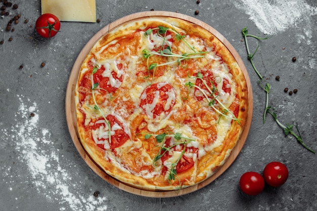 검은 돌 배경, 평면도에 피자 마르게리타. 토마토, 바질, 모짜렐라 치즈 피자 마르가리타가 가까이