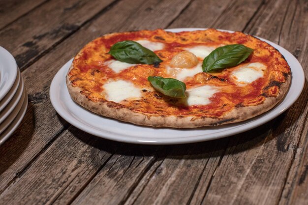 Foto pizza margherita su fondo di legno rustico scuro messa a fuoco selettiva da vicino