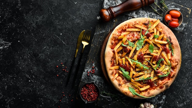 Foto pizza met frietjes en ketchup thuisbezorging van voedsel op een zwarte stenen achtergrond