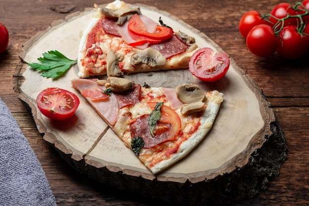 Pizza met ham en baconpaddestoelen en tomaten op een stuk hout op een bruine houten achtergrond