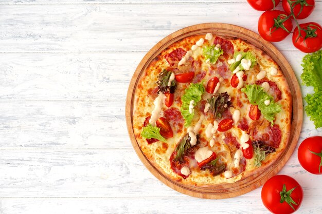 Pizza met ham en salade op houten