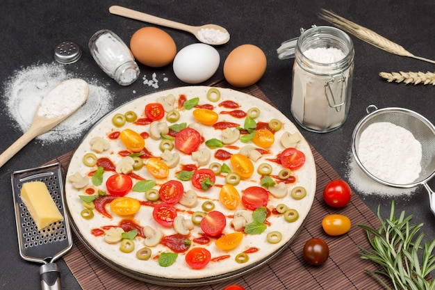 Pizza met ingrediënten is klaar om te bakken