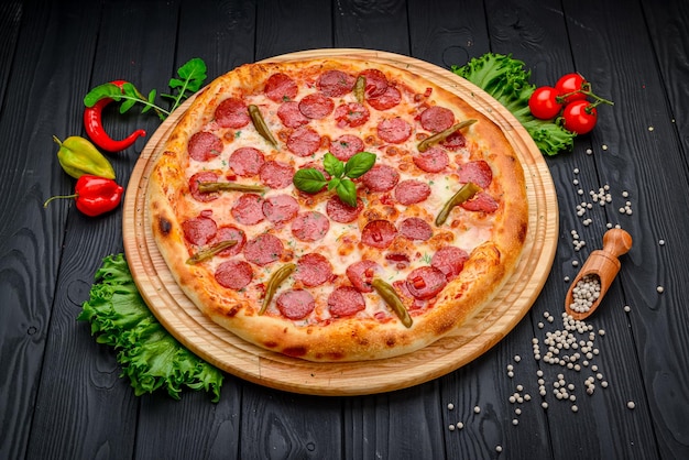 Pizza met Mozzarella kaas salami kippenvlees rundvlees ham Tomatensaus peper kruiden Italiaanse pizza op donkere achtergrond