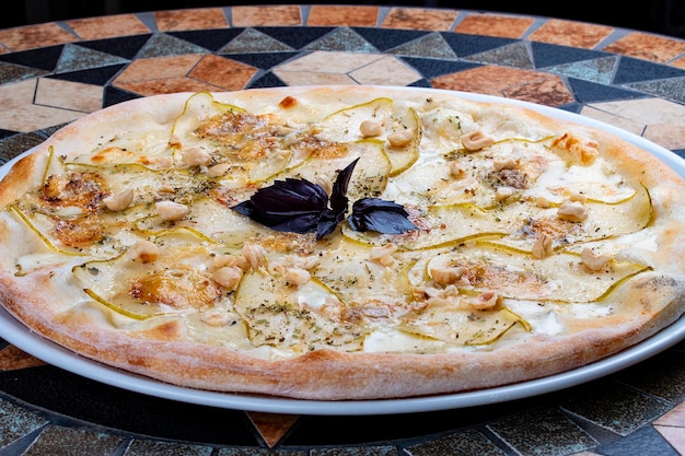 Pizza met peer en Gorgonzola kaas op een stenen tafel