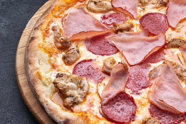 Pizza met vlees worst champignons op een grijze achtergrond