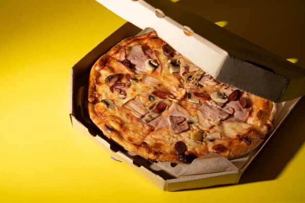 Pizza met worst en champignons Pizza in een bezorgdoos kun je je brief op een gele achtergrond zetten