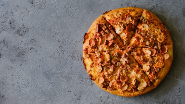 Pizza op rustieke grijze achtergrond, bovenaanzicht. Pizza met gehakt, selderij en mozzarella kaas close-up.