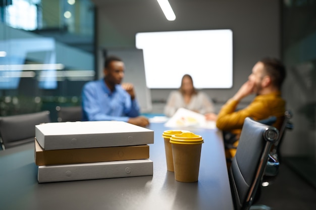 Pizza op tafel, zakenlunch in IT-kantoor