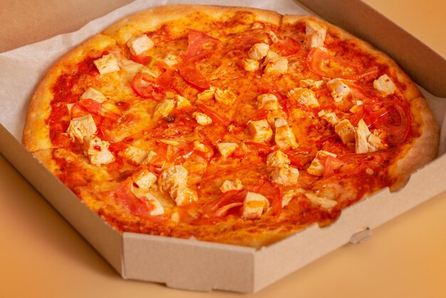 ベージュの背景に紙の有機包装のピザ鶏肉の部分と食品写真ピザ