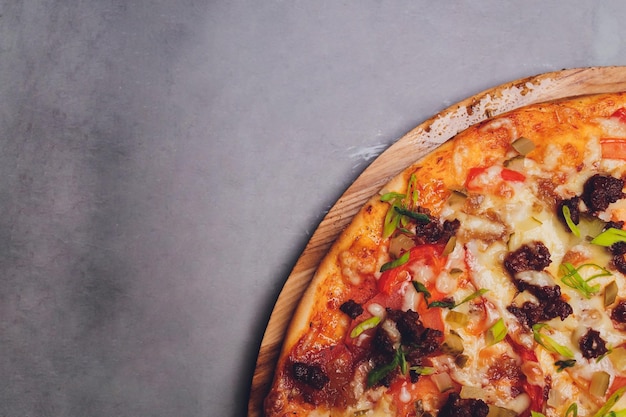 Pizza on paper on a wooden board Pizza on a black table closeup Healthy hot food