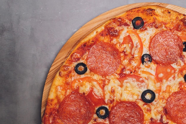 Foto pizza peperoni mozzarella origano su sfondo nero