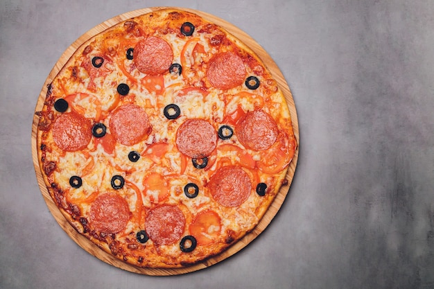 Pizza pepperoni, mozzarella, oregano on a black background.