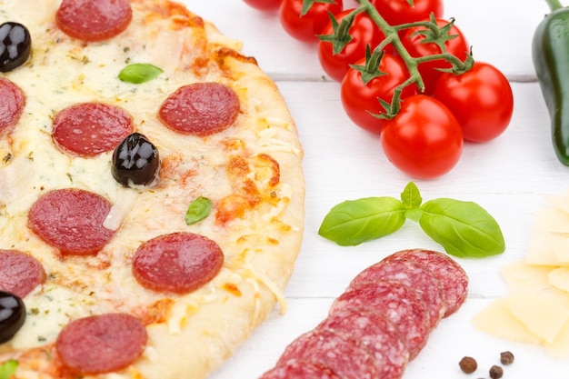Pizza pepperoni salami baking ingredients on wooden board
