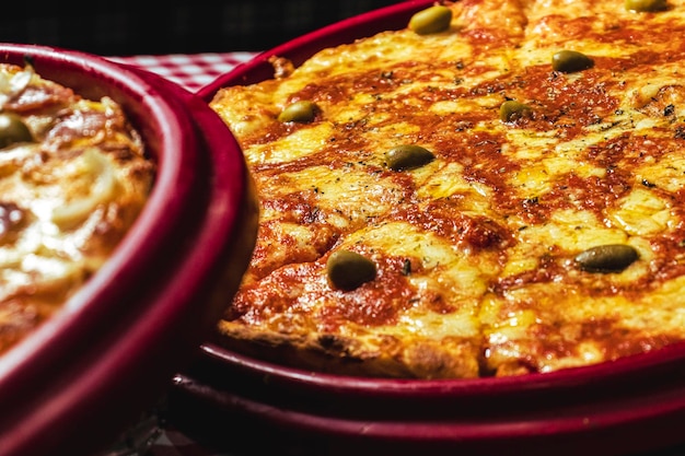 Photo a pizza and a pizza on a table with a pizza in the background