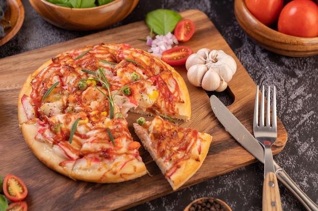 나무 접시 에 넣은 피자 에 고추 씨 와 함께 토마토 와 마늘 선택적 인 초점