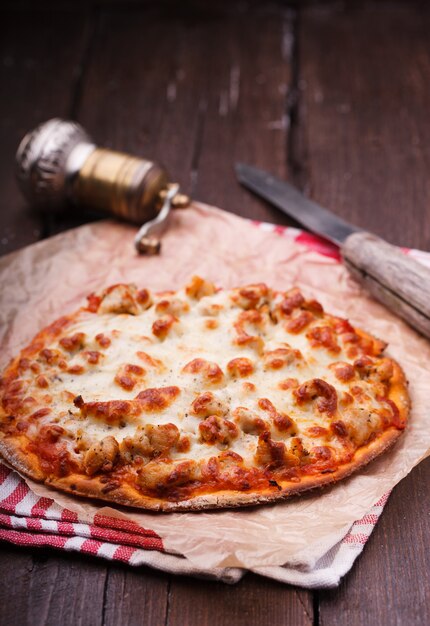 Pizza preparation surrounded by ingredients.