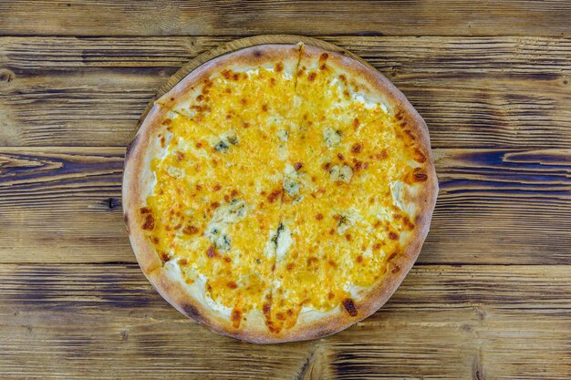 Pizza quattro formaggi four cheeses on a wooden background Top view