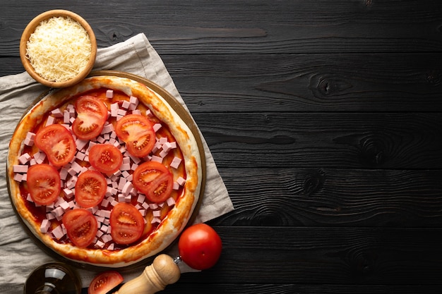 Pizza ready for the oven on a wooden background, place for\
text, top view.