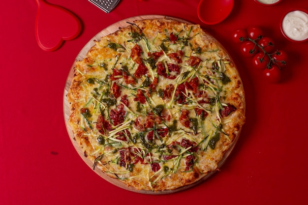 Pizza over a red fabric with several red utensils around