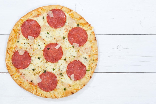 Pizza salami van bovenaf copyspace kopie ruimte op houten bord