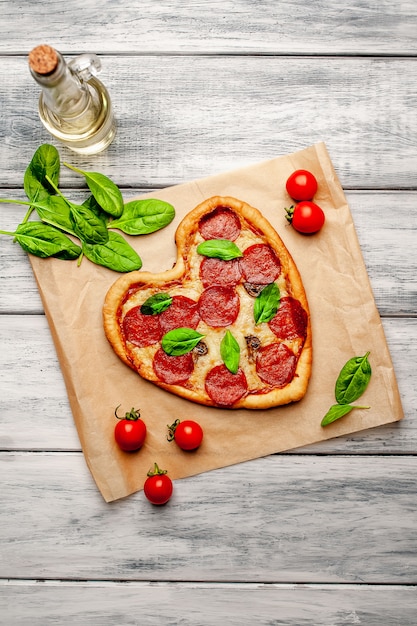 Pizza in the shape of a heart on a wooden table