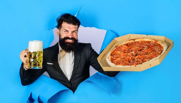 Pizza time happy bearded man with pizza and beer mug looking through paper restaurant or pizzeria