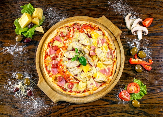 Pizza top view with ingredients on wood