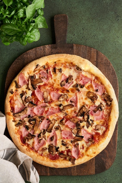 Pizza Traditional Bacon pizza with ham mushrooms pickled cucumber and cheese and cooking ingredients tomatoes basil on wooden table backgrounds Italian Traditional food Top view Mock up