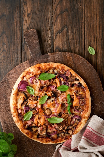 Pizza Traditional Bacon pizza with ham mushrooms pickled cucumber and cheese and cooking ingredients tomatoes basil on wooden table backgrounds Italian Traditional food Top view Mock up