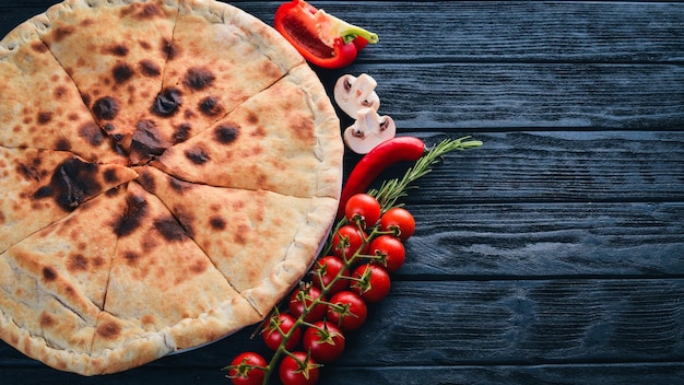 Pizza Volcano Gorgonzola cheese cherry tomatoes fresh vegetables and spices On a wooden background Free space for your text Top view