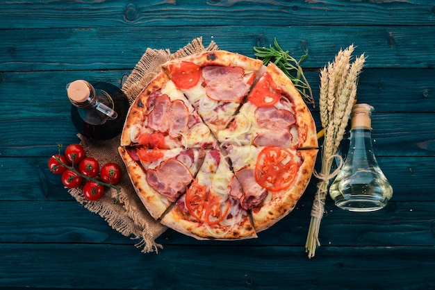 Pizza with bacon tomatoes and onion Italian cuisine On a wooden background Free space for text Top view