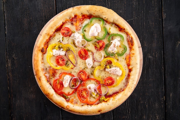 Pizza with bell pepper and mozzarella on the dark wooden table