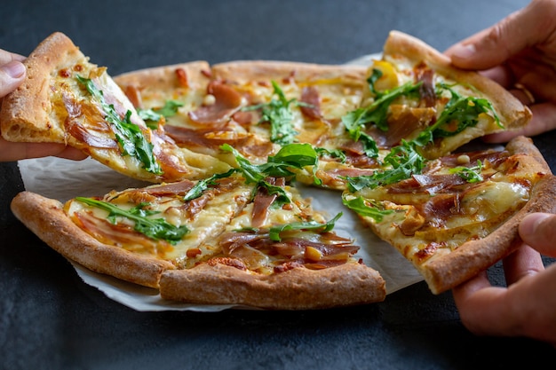 Pizza with cheese, arugula, pine nuts, and pear