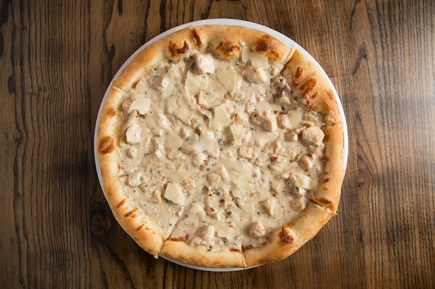 Pizza with cheese and chicken in carbonara sauce