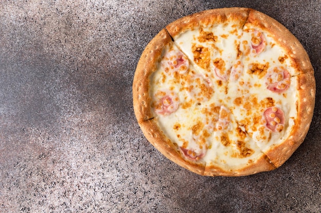 Pizza with cheese on a dark background. Copy space.