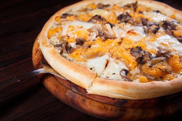 나무 접시에 치즈와 버섯 피자