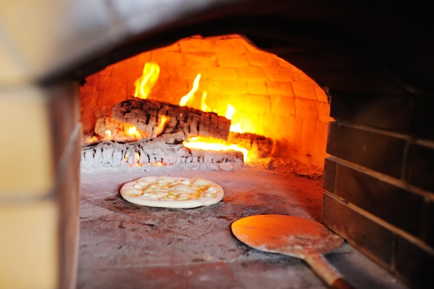 Pizza with cheese in the oven close-up