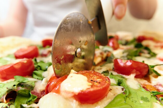 Pizza with cheese, tomatoes, spinach and smoked sausage