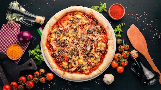 Pizza with chicken, vegetables and mushrooms. On a wooden background. Top view. Free copy space.