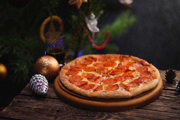 Pizza with Christmas decorations on wooden table