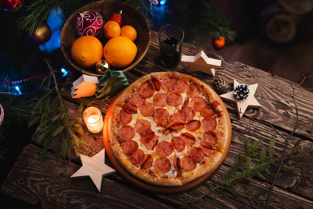 Pizza with Christmas decorations on wooden table