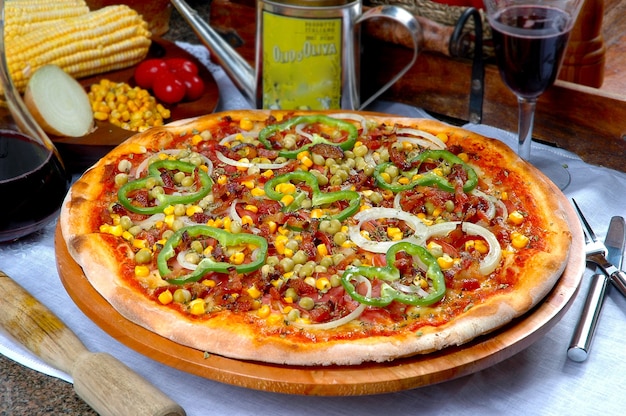 Pizza with corn, bacon, chili, onion, pea