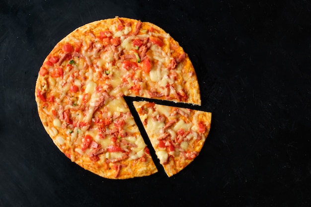 Pizza with cut slice, top view