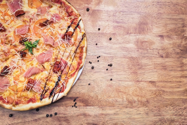 Pizza with dried tomatoes and prosciutto