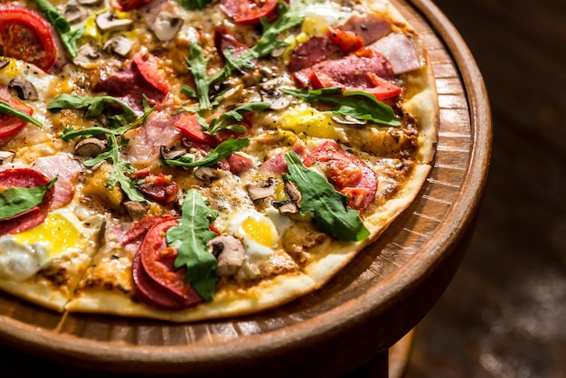 Pizza with egg and bacon on a wooden background