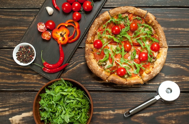 pizza with ingredients on wood background