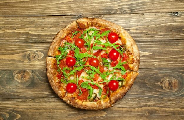 pizza with ingredients on wood background